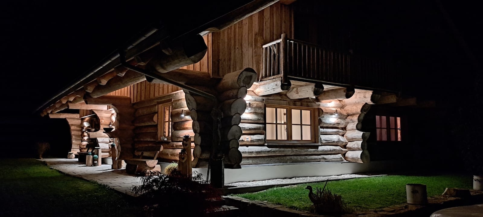 Drei-Flüsse-Blockhaus bei Nacht beleuchtet